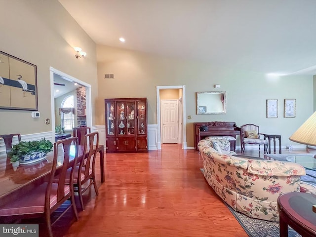 bedroom with recessed lighting, visible vents, wainscoting, wood finished floors, and high vaulted ceiling