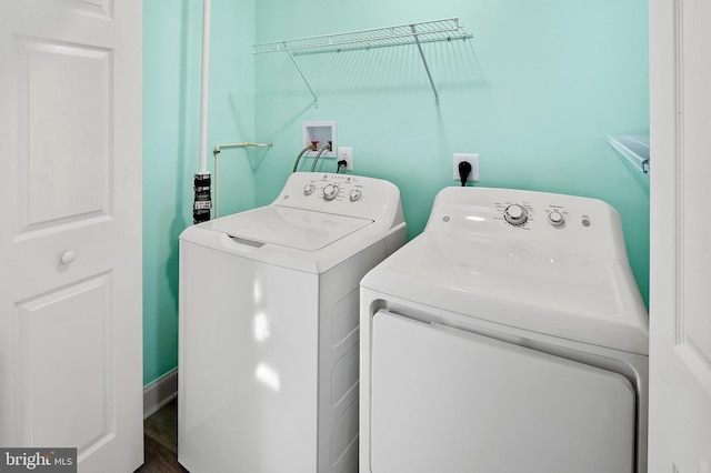 laundry area with laundry area, washer and clothes dryer, and wood finished floors