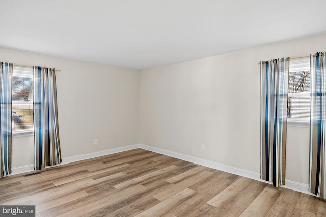 unfurnished room with light wood-style flooring and baseboards