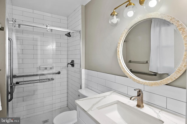 bathroom with a stall shower, vanity, and toilet