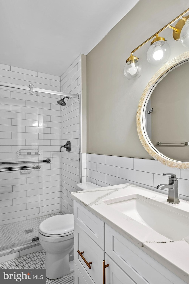 bathroom featuring toilet, a stall shower, tile patterned floors, and vanity