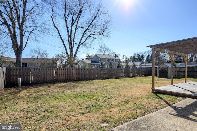 view of yard with a storage shed, an outbuilding, a fenced backyard, and a residential view