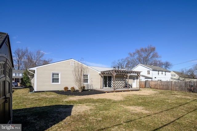 rear view of property featuring a lawn, fence, a deck, and a pergola