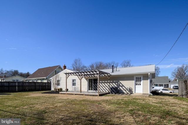 rear view of house featuring a lawn, a chimney, fence, and a pergola