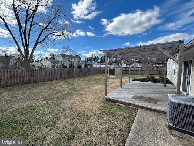 view of yard with an outbuilding, a fenced backyard, central air condition unit, a storage shed, and a pergola