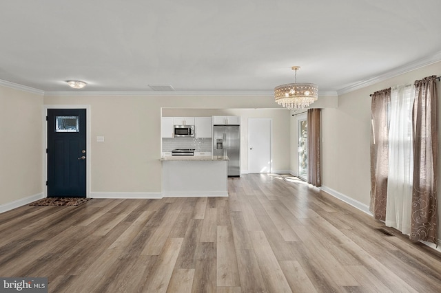 unfurnished living room with light wood-style flooring, ornamental molding, and baseboards