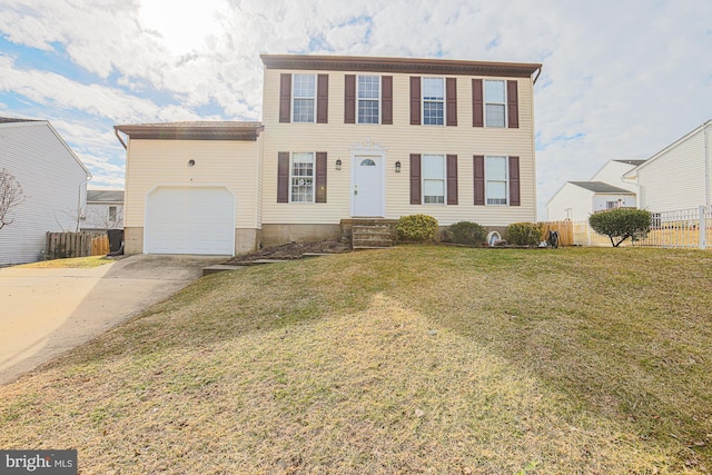 colonial home with a front lawn, concrete driveway, fence, and an attached garage