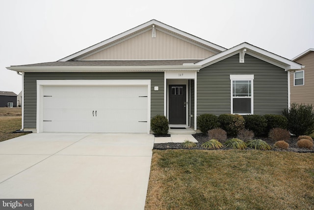 ranch-style house with a garage, concrete driveway, roof with shingles, and a front yard