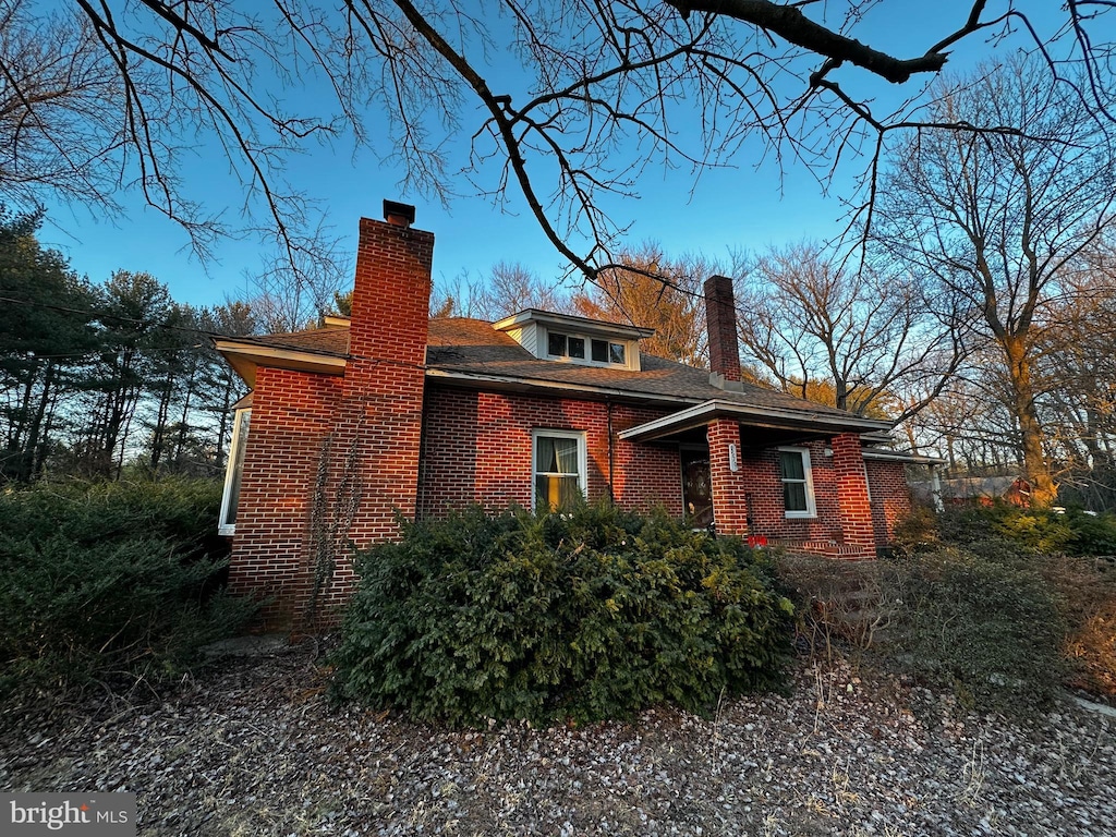 view of home's exterior with a chimney and brick siding