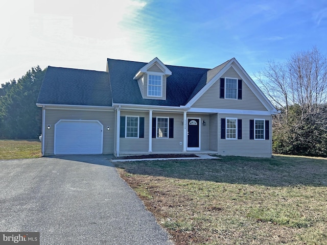 new england style home featuring an attached garage, a shingled roof, a front lawn, and aphalt driveway