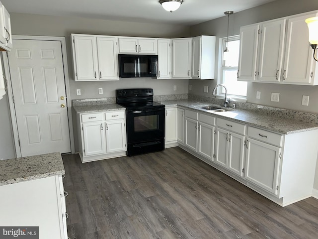 kitchen with white cabinetry, a sink, decorative light fixtures, and black appliances