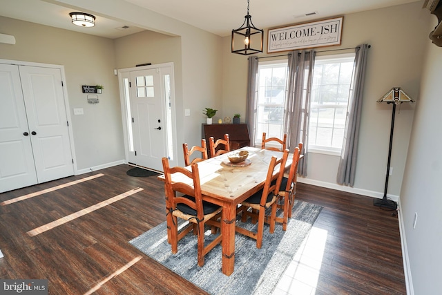 dining space featuring dark wood-style floors, visible vents, and baseboards