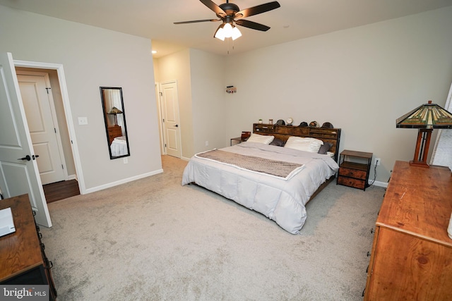 bedroom with light colored carpet, ceiling fan, and baseboards