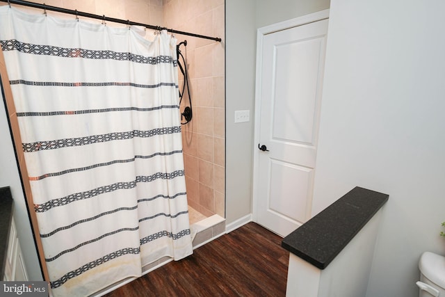 bathroom with a shower stall and wood finished floors