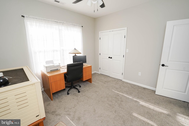 home office featuring light carpet, a ceiling fan, and baseboards