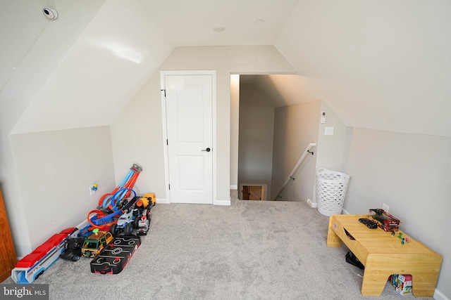 playroom featuring vaulted ceiling and light carpet