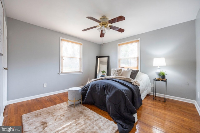 bedroom featuring light wood finished floors, baseboards, and a ceiling fan