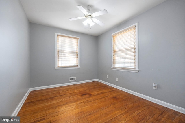 empty room with visible vents, baseboards, a ceiling fan, and wood finished floors