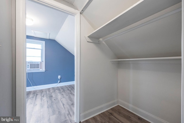 walk in closet featuring cooling unit, vaulted ceiling, and wood finished floors