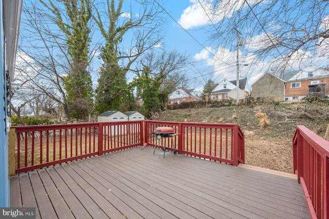 deck with a shed, a residential view, and an outdoor structure