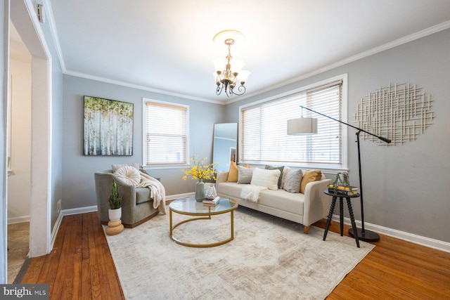 living room with crown molding, baseboards, wood finished floors, and an inviting chandelier