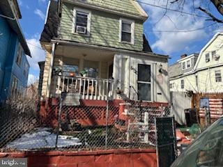 back of house featuring fence and a porch