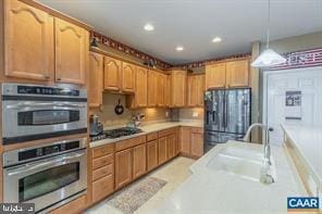 kitchen with recessed lighting, light countertops, hanging light fixtures, stainless steel double oven, and freestanding refrigerator