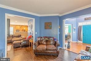 living room featuring ornamental molding and wood finished floors