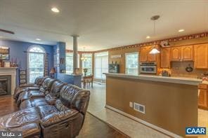 kitchen featuring visible vents, oven, light countertops, a fireplace, and recessed lighting