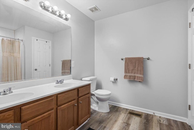 bathroom with visible vents, a sink, and wood finished floors