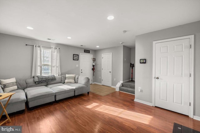 living area with recessed lighting, visible vents, stairway, wood finished floors, and baseboards