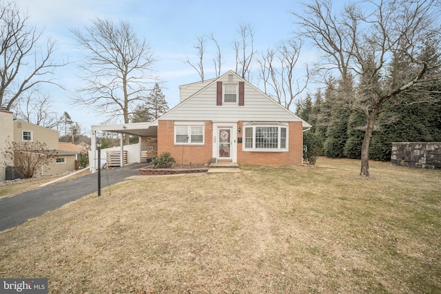 bungalow with brick siding, aphalt driveway, a front lawn, and an attached carport