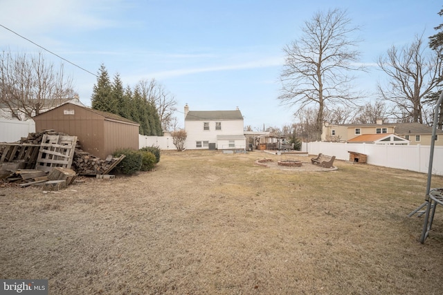 view of yard featuring a fenced backyard, a storage unit, and an outbuilding