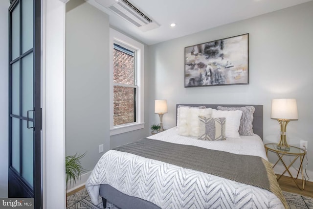 bedroom featuring wood finished floors, visible vents, and recessed lighting