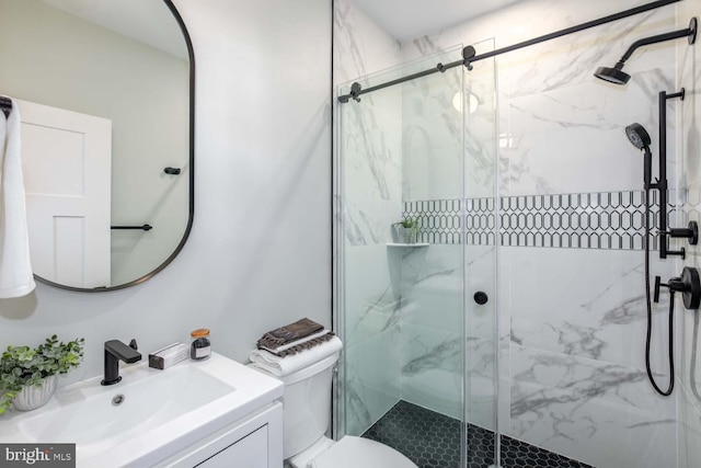 full bath with toilet, a marble finish shower, and vanity