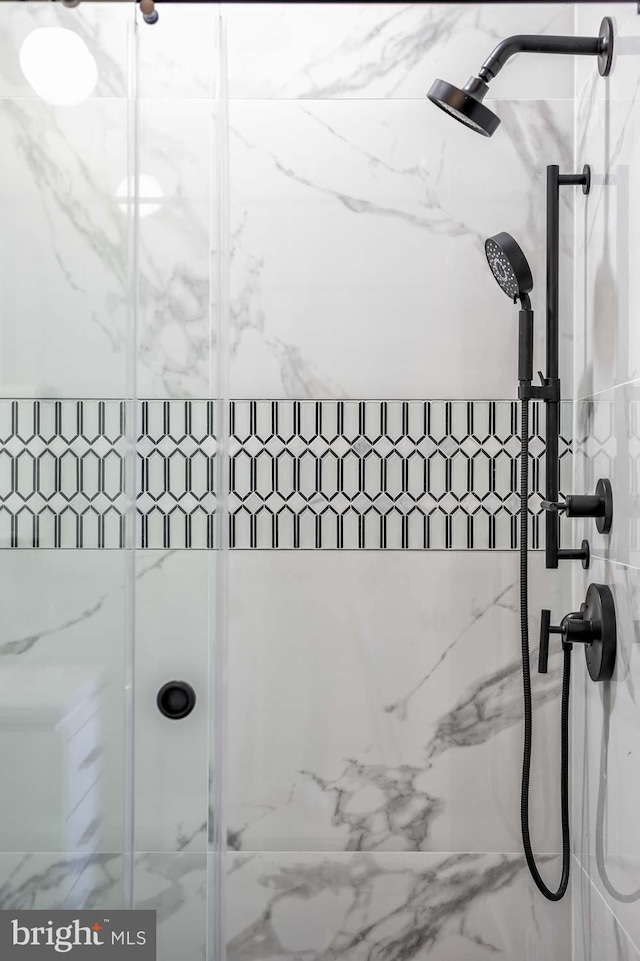 bathroom featuring a marble finish shower