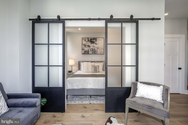 living area with a barn door and wood finished floors