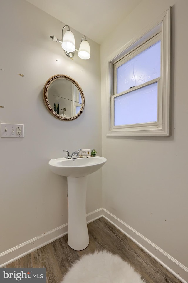 bathroom with a sink, wood finished floors, and baseboards