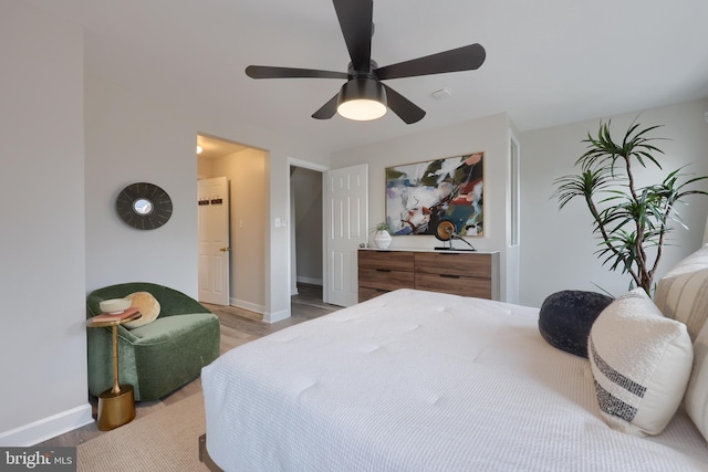 bedroom featuring ceiling fan, light wood-style flooring, and baseboards