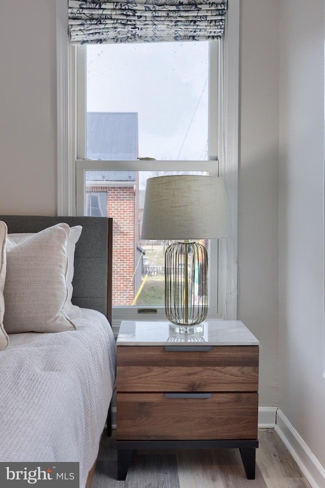 bedroom with baseboards and wood finished floors