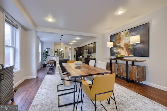 dining space with dark wood finished floors, a wealth of natural light, and baseboards