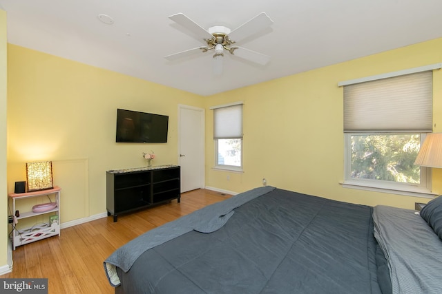 bedroom featuring a ceiling fan, baseboards, and wood finished floors