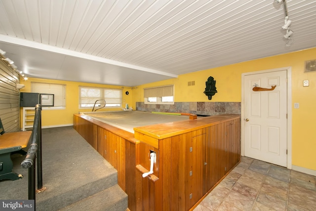 kitchen featuring rail lighting, baseboards, visible vents, and brown cabinets