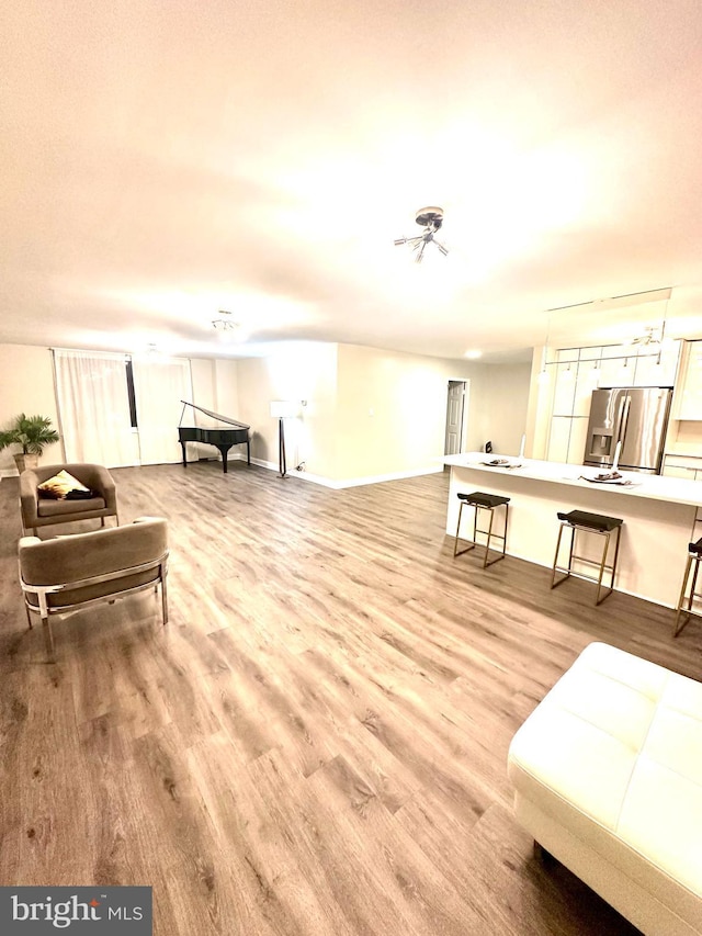 living area with light wood-style floors and baseboards