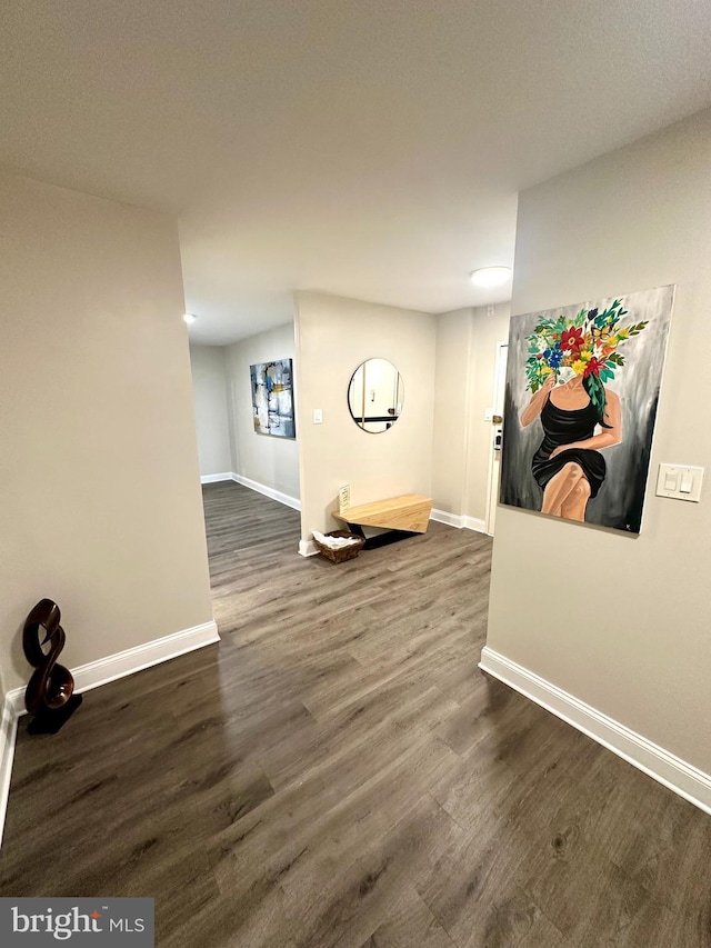 exercise area featuring baseboards and dark wood-type flooring