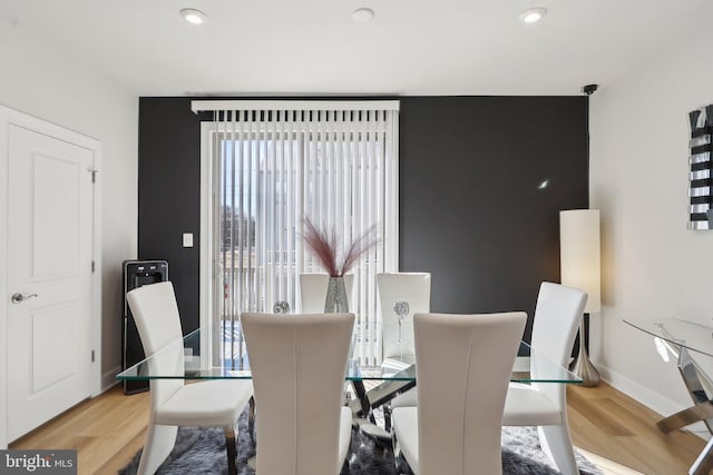 dining space featuring baseboards, wood finished floors, and recessed lighting