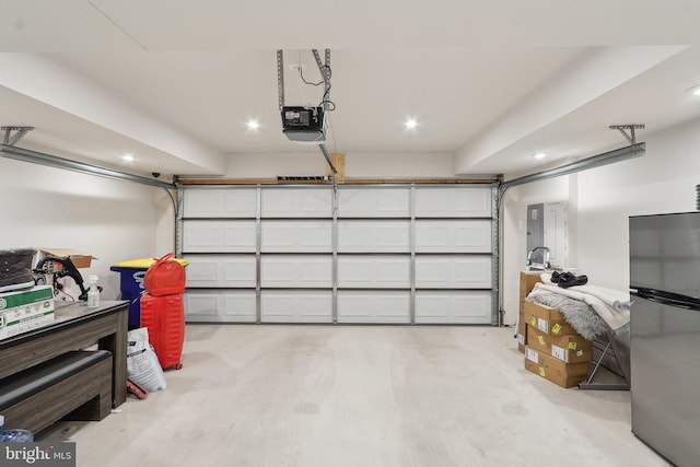 garage featuring a garage door opener and freestanding refrigerator