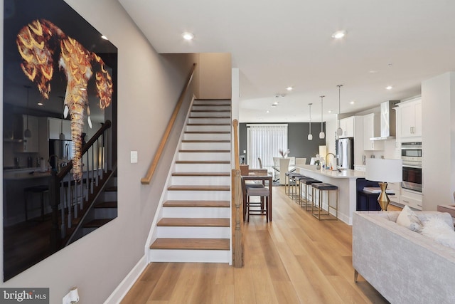 stairs with recessed lighting, baseboards, and wood finished floors