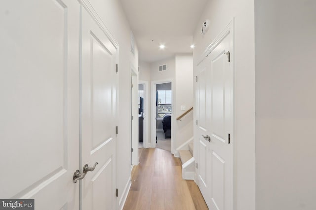 hall with light wood finished floors, visible vents, and recessed lighting