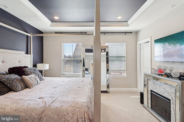 bedroom with light carpet, baseboards, a raised ceiling, and crown molding